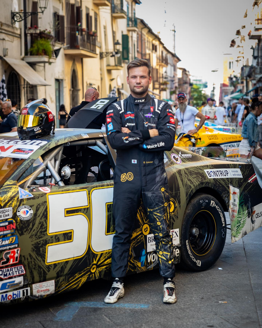 a person in a racing suit standing in the middle of a street Gil Linster Hendriks Motorsport NASCAR EuroNASCAR Kimmel Racing