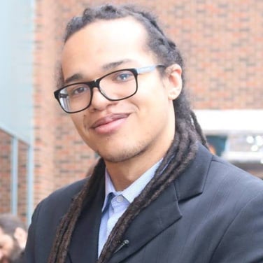 a person with dreadlocks wearing glasses and a suit Front-End Web Developer Total Marketeer NASCAR EuroNASCAR